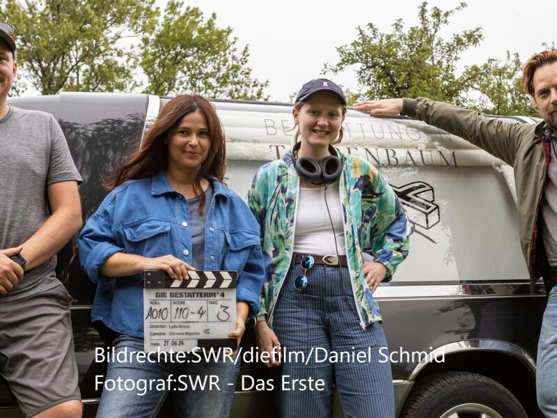 Regisseurin Lydia Bruna (2.v.r.) mit Hauptdarstellerin Anna Fischer, Hauptdarsteller Christoph Letkowski (rechts), Kameramann Clemens Majunke (links) und dem Leichenwagen der Firma Taubenbaum. © SWR/diefilm/Daniel Schmid,